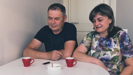 The couple of adult persons are smoking medical marijuana joint. Smoking hemp indoors. Cannabis is a concept of herbal medicineの写真素材