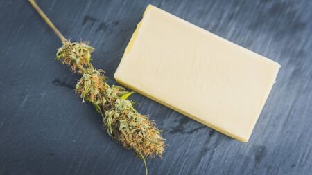 Preparing to cooking cake with cannabis butter. Concept of using marijuana in food industry. Cake with CBD cannabis and buds of marijuana on the tableの写真素材