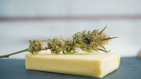Preparing to cooking cake with cannabis butter. Concept of using marijuana in food industry. Cake with CBD cannabis and buds of marijuana on the tableの写真素材
