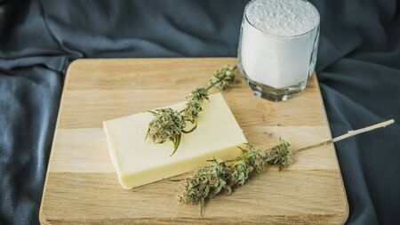 Preparing to cooking cake with cannabis butter. Concept of using marijuana in food industry. Cake with CBD cannabis and buds of marijuana on the tableの写真素材
