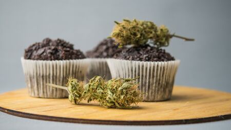 Homemade cakes with cannabis and buds of marijuana. Concept of using marijuana in food industry. Cake with CBD cannabis and buds of marijuana on the grey backgroundの写真素材