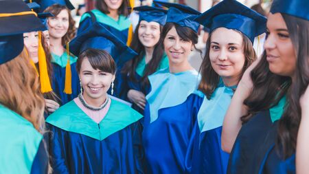A group of young female graduates. Female graduate is smiling against the background of university...