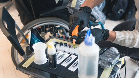Close-up of tattoo artist work place parts and paint, machines and other equipment. Professional...