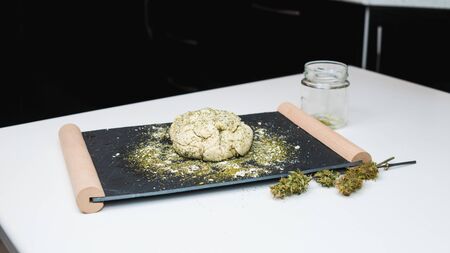 Preparing to cooking hemp cake or bread. Close-up of fresh dough with cannabis flour. Concept of uses marijuana in a food industryの写真素材