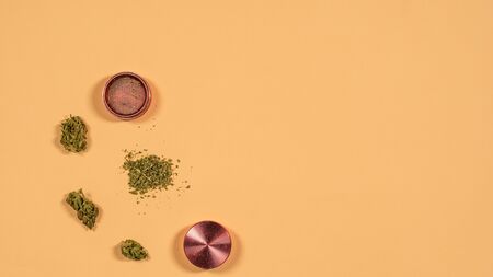 Top view of grinder with fresh marijuana buds on the yellow background, Flat lay. Concept of herbal and alternative medicineの写真素材