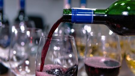 Close-up of red wine pouring into a wine glass. Concept of restaurant, bar and catering serviceの写真素材