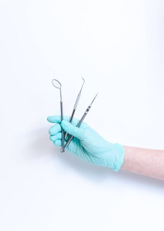 Close-up of female dentist doctor hand holding dental tools. The instruments in dental office. Isolated on white backgroundの写真素材