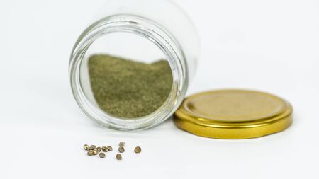 Close-up of glass jar with hashish and cannabis seeds isolated on white background. Hemp is a concept of herbal and alternative medicine.の写真素材