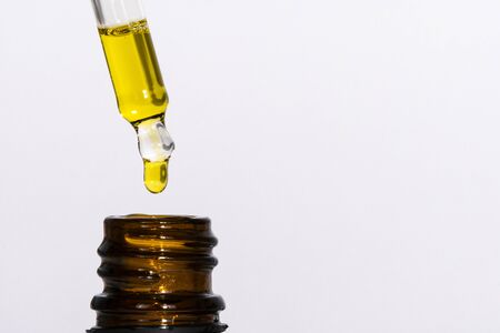 Macro close-up of pipette with hemp oil. Medicinal extract oil in a bottle. Concept of using...