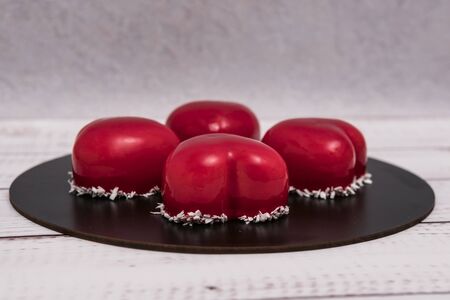 Close-up of mousse cake with red mirror glaze. Cooking french dessert. Frozen mirror icing on the cake. Baking and confectionery concept.の写真素材