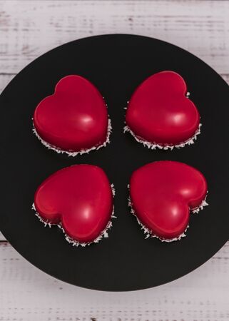 Close-up of mousse cake with red mirror glaze. Cooking french dessert. Frozen mirror icing on the cake. Baking and confectionery concept.の写真素材