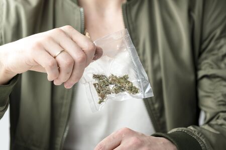 Close-up of male hands holding medical marijuana buds in vacuum seal bags. Cannabis is a concept of herbal or alternative medicineの写真素材