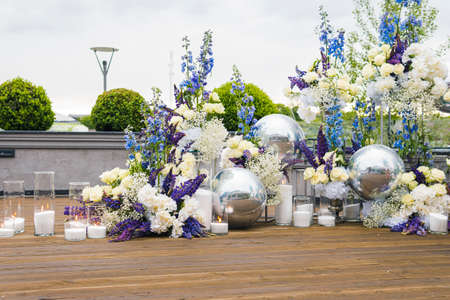 Wedding reception with white, blu and violet flower and candles, outdoors. Elegant luxury wedding decoration composition on ceremony place or photo zoneの写真素材