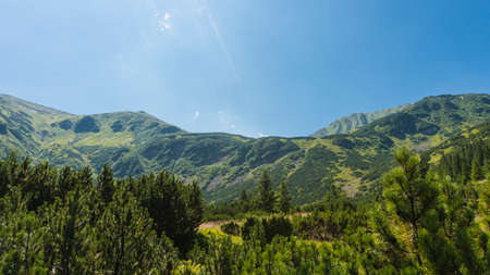 Amazing mountain landscape with blue sky with white clouds, sunny summer day in Carpathians, Ukraine. Natural outdoor travel background.の写真素材