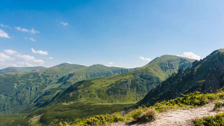 Amazing mountain landscape with blue sky with white clouds, sunny summer day in Carpathians, Ukraine. Natural outdoor travel background.の写真素材