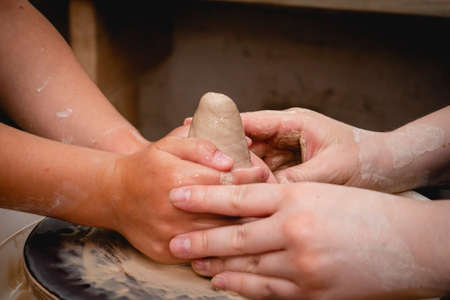 Potter working on potters wheel with clay. Process of making ceramic tableware in pottery workshop....