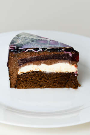 Close-up mousse cake covered black, red and white mirror glaze. French dessert. Frozen mirror icing on the cake. Baking and confectionery concept.の写真素材