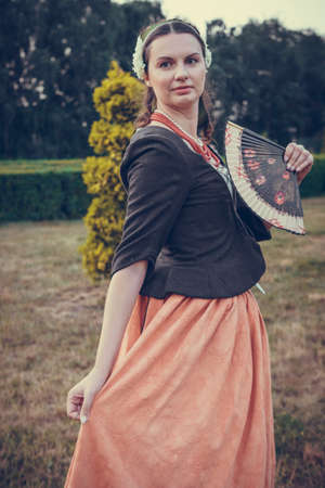 Portrait of brunette woman dressed in historical Baroque clothes with old fashion hairstyle, outdoors. Middle class medieval dressの写真素材