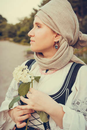 Portrait of woman dressed in historical Baroque clothes with a headscarf, outdoors. Middle class medieval dressの写真素材