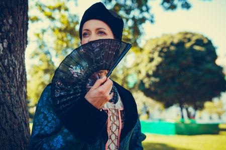 Portrait of woman dressed in blue historical Baroque clothes with old fashion hairstyle, outdoors. Luxurious medieval dressの写真素材