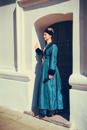 Portrait of woman dressed in blue historical Baroque clothes with old fashion hairstyle, outdoors. Luxurious medieval dressの写真素材