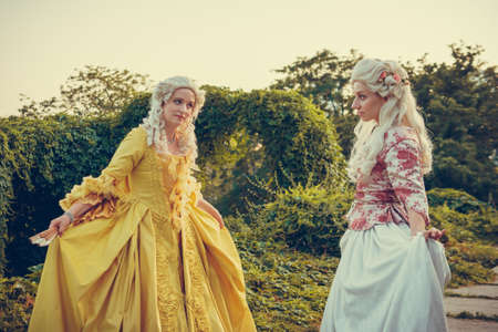 Portrait of two blonde woman dressed in historical Baroque clothes with old fashion hairstyle,...