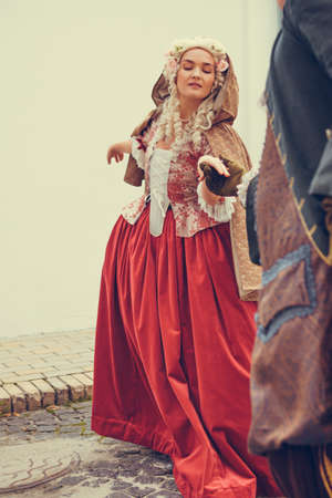 Portrait of blonde woman dressed in historical Baroque clothes with old fashion hairstyle, outdoors. Luxurious medieval dressの写真素材