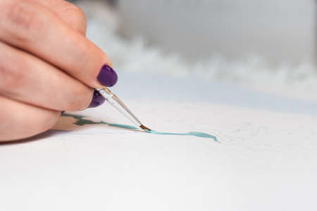 The adult woman painting by numbers indoors. Concepts of leisure activity, hobby and relaxの写真素材