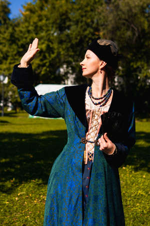Portrait of woman dressed in blue historical Baroque clothes with old fashion hairstyle, outdoors....