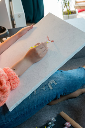 The adult woman painting by numbers, pastel colors, drawing on canvas. Concepts of leisure activity, hobby and relaxの写真素材
