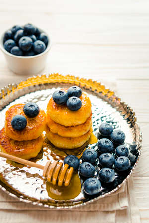 Homemade cheesecake with freshly picked juicy blueberries in the plate on wooden background, close up. blueberry background. Concept of healthy nutrition, organic food, breakfastの写真素材
