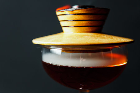 Alcoholic drink. A cocktail with whiskey or cognac with fire and smoke close-up, dark black...