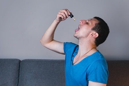 Adult man using and holding medical cannabis oil. CBD Concept of herbal and alternative medicineの写真素材