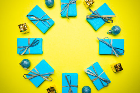 Yellow blue Christmas and New Year background with gift box and decorations, flat lay. Concept of greeting card for holidaysの写真素材