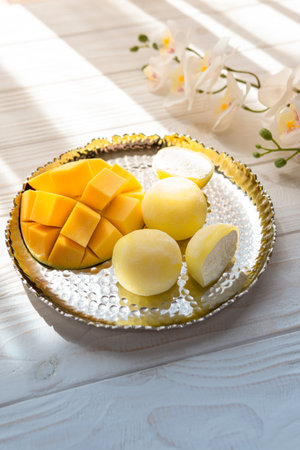 Tasty dessert Mochi with mango fruit on wooden background, close up. traditional japanese rice cake dessertの写真素材