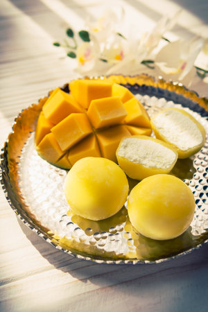Tasty dessert Mochi with mango fruit on wooden background, close up. traditional japanese rice cake dessertの写真素材