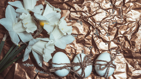 White Easter eggs with flowers on golden background, close up. Concept of Easter Sunday, religious traditions and symbolismの写真素材
