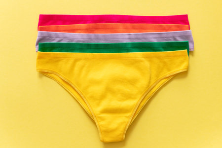 Set of colorful underpants on yellow background, close up. Cotton panties. women's underwear. top...