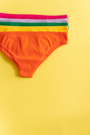 Set of colorful underpants on yellow background, close up. Cotton panties. women's underwear. top viewの写真素材
