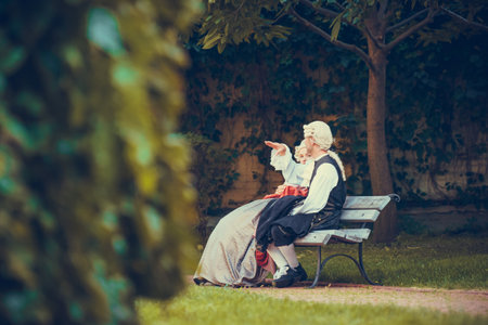 Portrait of blonde woman and man dressed in historical Baroque clothes with old fashion hairstyle, outdoors. Luxurious medieval dress. Retro style and historical clothes conceptsの写真素材