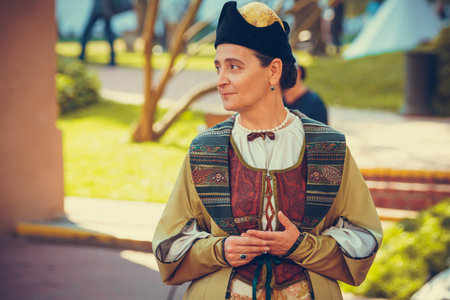 Portrait of woman dressed in historical Baroque clothes with old fashion hairstyle, outdoors. Golden...