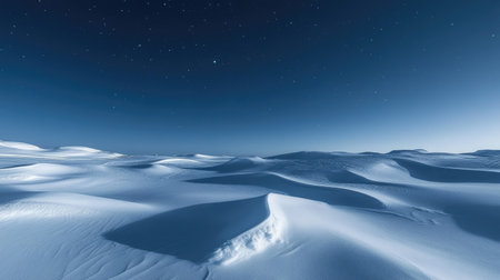 Snow drifts glowing in moonlight, creating a peaceful and ethereal winter landscape under a clear, starry skyの素材