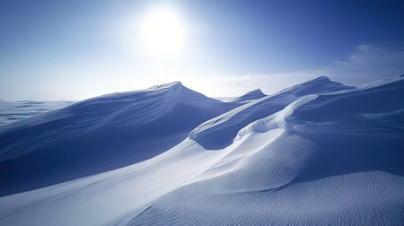 Snow drifts sculpted by the wind, their edges sharp and glistening under bright sunlight, with a vast cloudless sky aboveの素材
