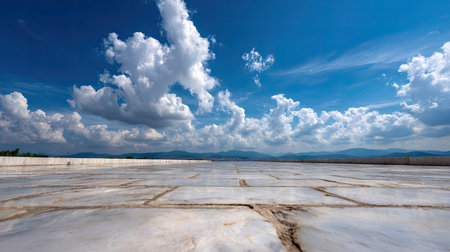 Wide-angle view of a clean marble floor stretching into the distance under a vibrant blue sky with scattered cloudsの素材