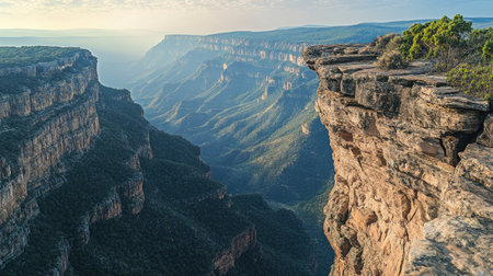 Steep rock cliff carved by time and erosion, with vast mountain wilderness stretching out beyond itの素材