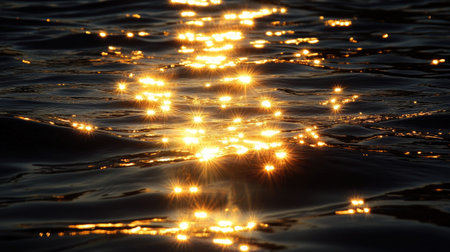 A burst of golden light rays glowing and dancing in the darkness, casting soft reflections on the surface.の素材