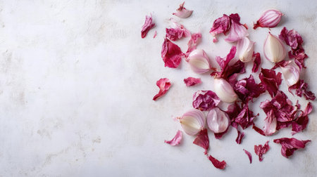 Whole and peeled red onions with papery skins scattered casually across a white surface.の素材