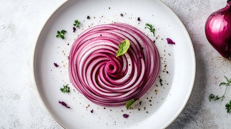 Thinly sliced red onion rings arranged in a concentric pattern on a white ceramic plate.の素材