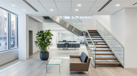 A modern staircase inside an office building, surrounded by glass railings and bright white walls with sleek finishes.の素材