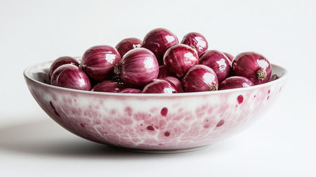 A bowl filled with glossy red onions, placed against a white background for a clean, fresh look.の素材